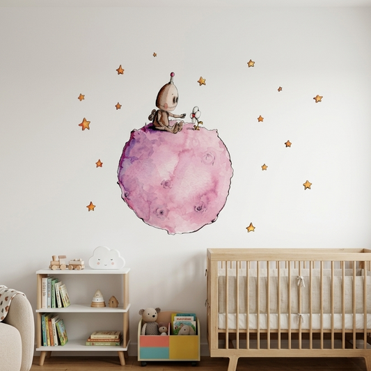 Vinilo decorativo infantil que muestra un robot sentado sobre un planeta rosa, rodeado de estrellas y sosteniendo una flor.