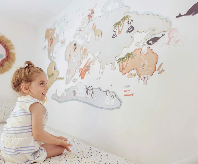 Vinilo decorativo de mapa del mundo con animales ilustrados que decoran diferentes continentes.