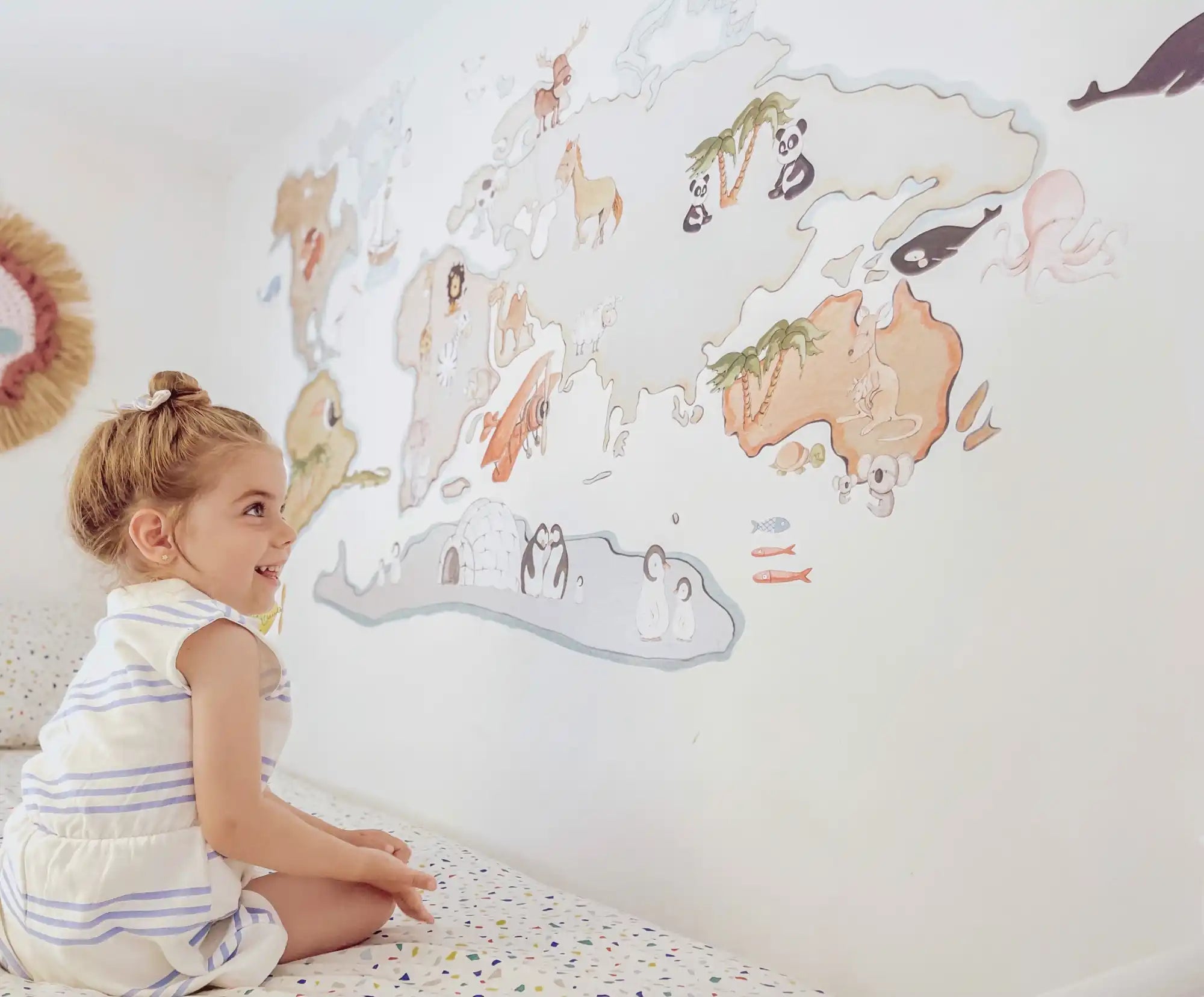 Vinilo decorativo de mapa del mundo con animales ilustrados que decoran diferentes continentes.